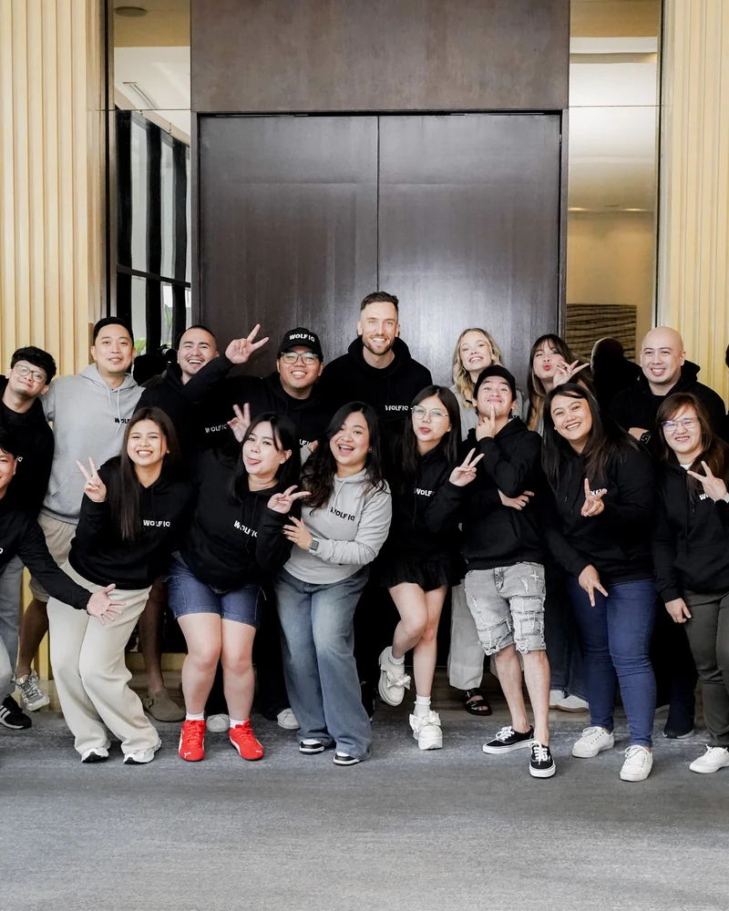 The full Wolf IQ team in branded hoodies, arms out