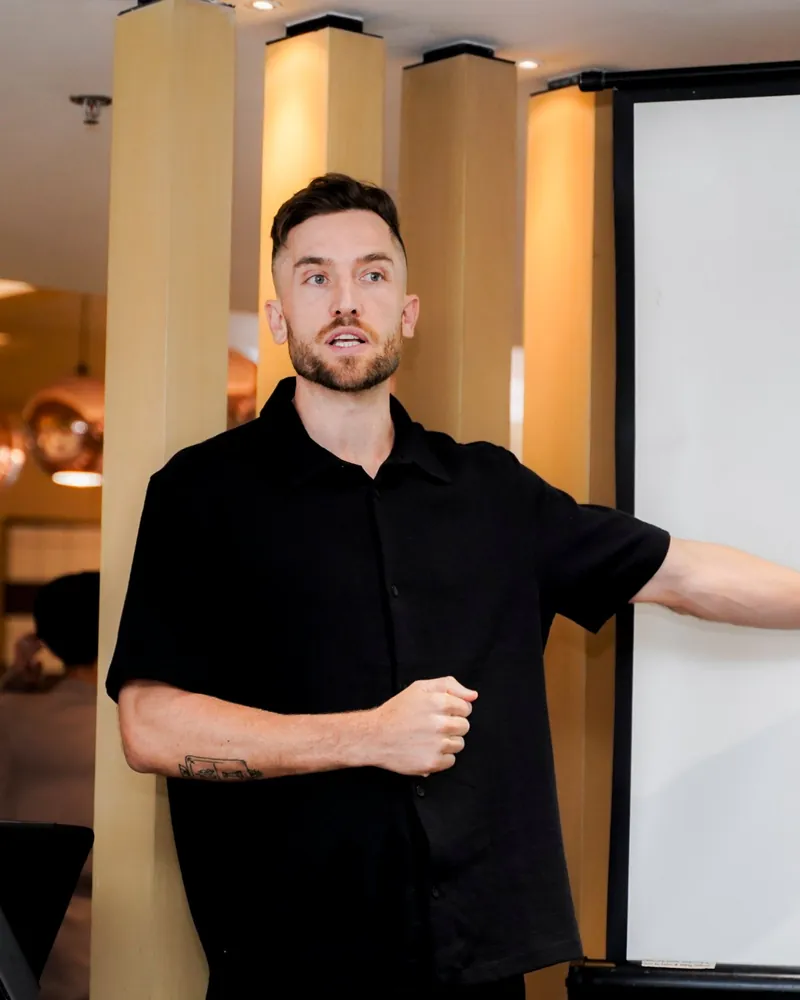 Andy Crebar presenting to the team in front of a projector screen